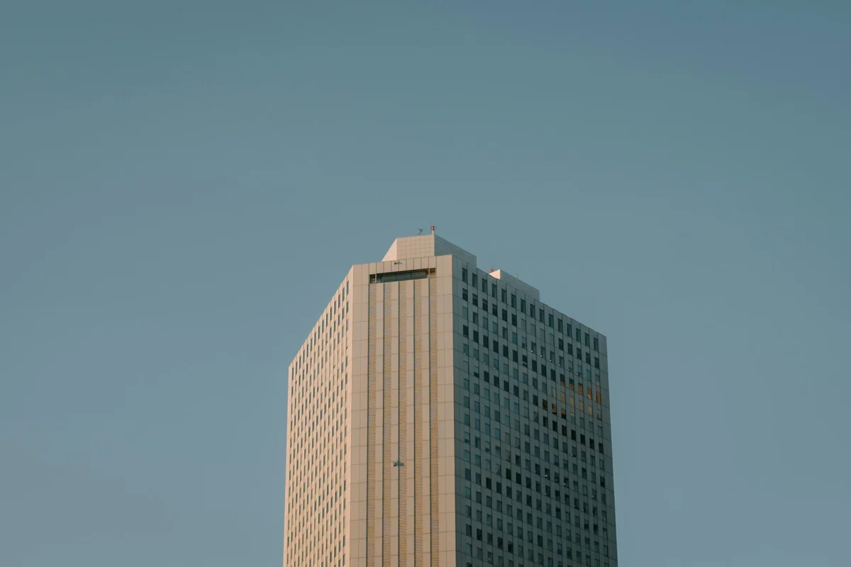 Tall commercial office building beneath a clear blue sky