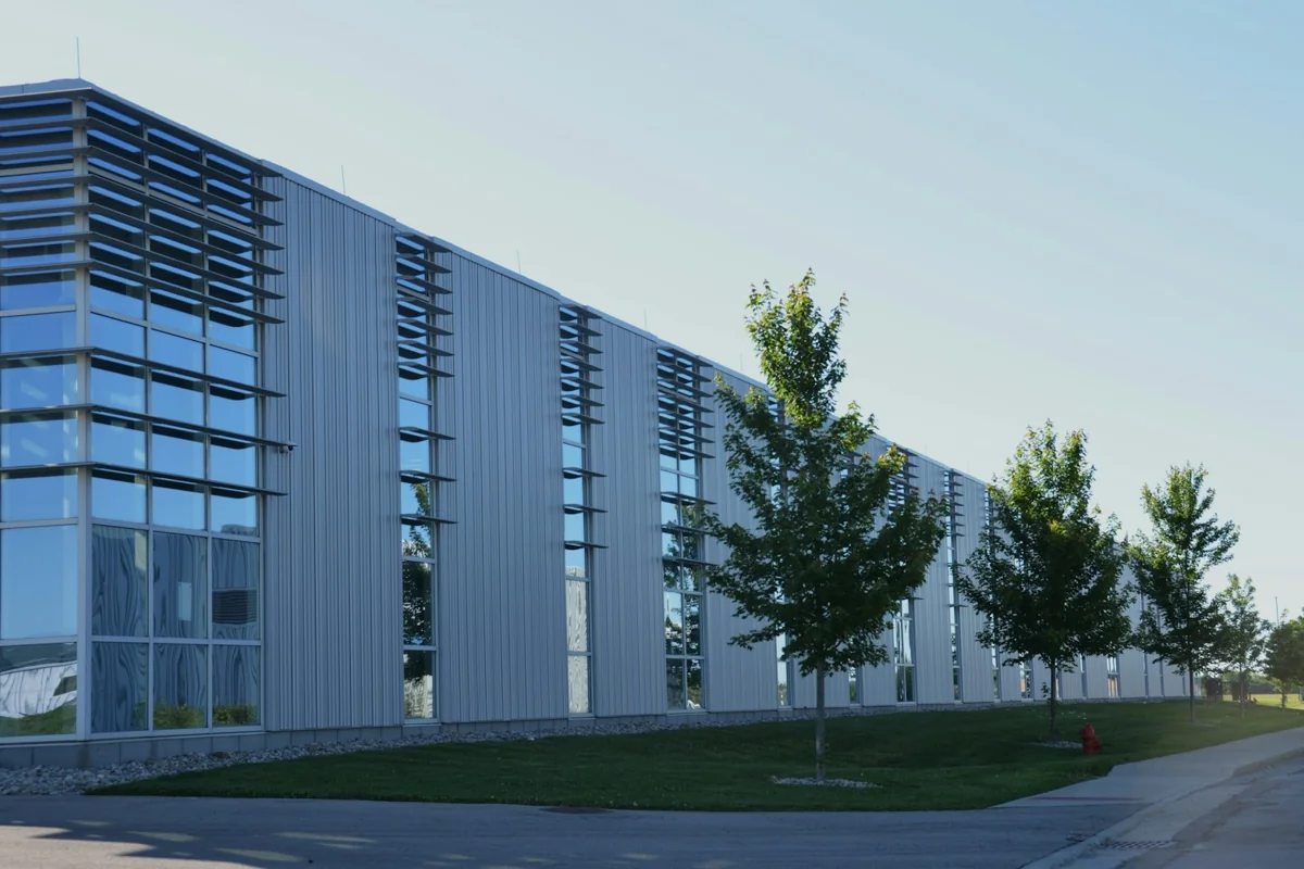 Modern commercial building with glazed windows and trees beside the facade