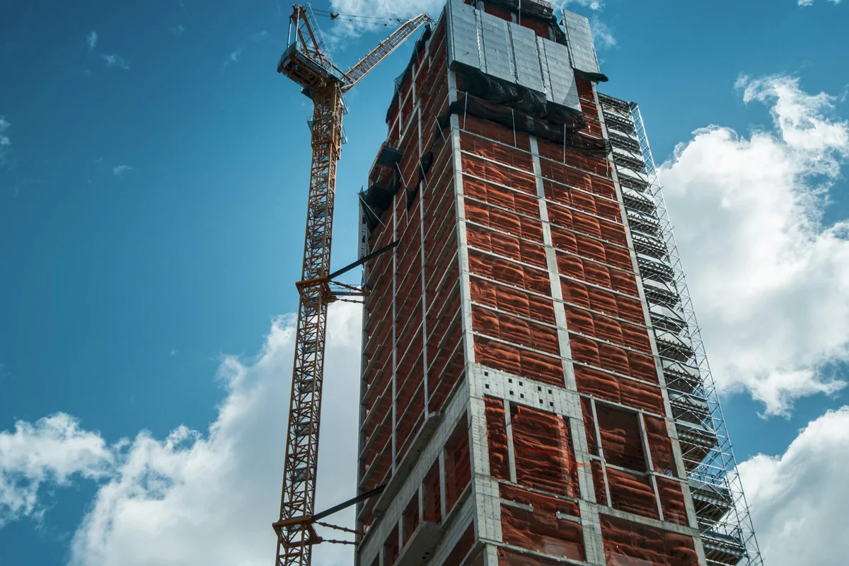 Multi-storey construction site with a tower crane and scaffolded building