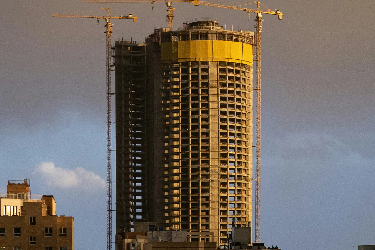 High-rise building under construction with tower cranes