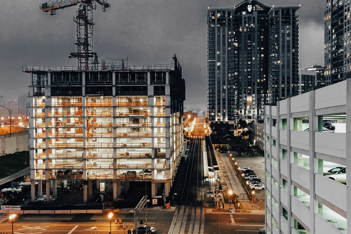 Illuminated multi-storey construction site and tower cranes at night