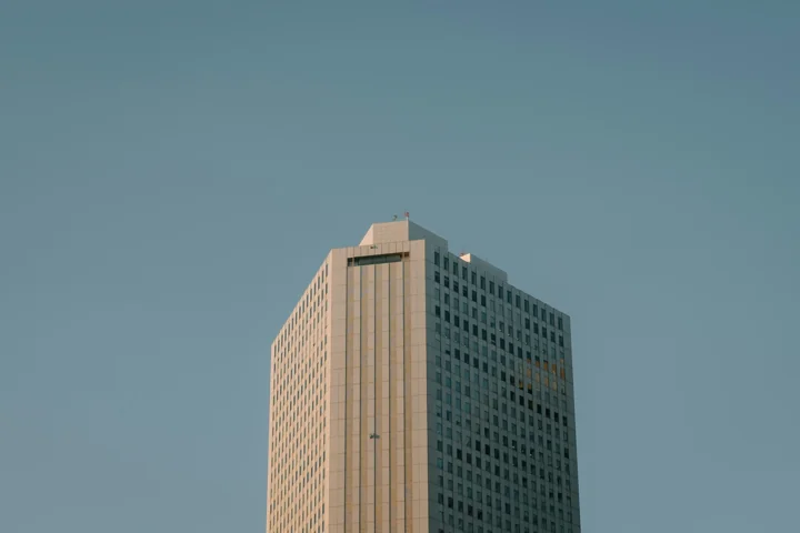 Tall commercial office building beneath a clear blue sky