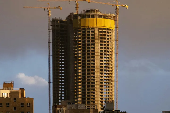 High-rise building under construction with tower cranes