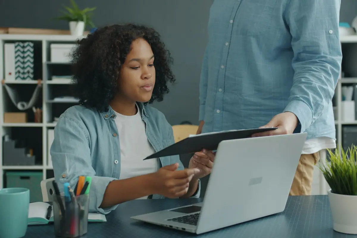 Two colleagues reviewing documents together at an office desk