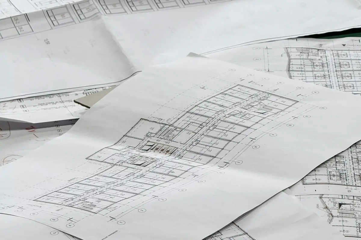 Architectural and services drawings spread out on a desk