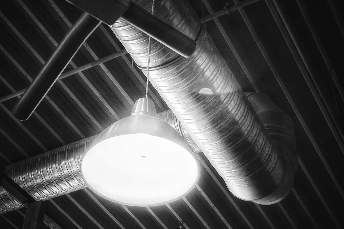 Industrial ceiling with ventilation ductwork and a hanging lamp