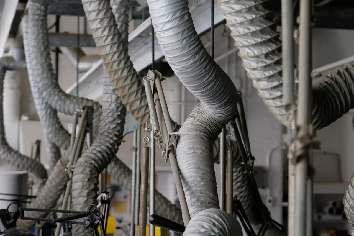 Flexible ventilation ducts in an industrial workspace ceiling