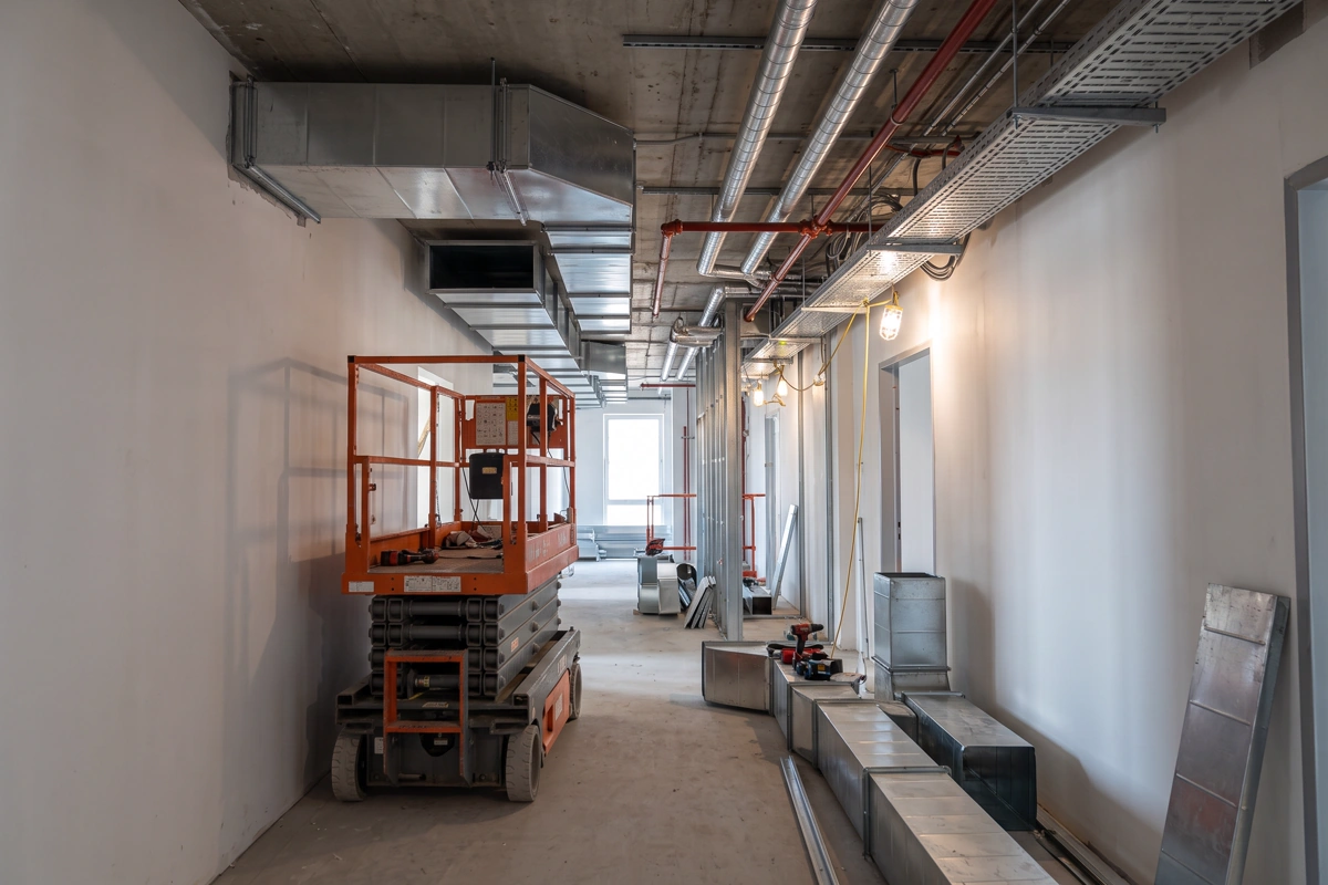 Unfinished corridor with ductwork, access platform and components awaiting installation