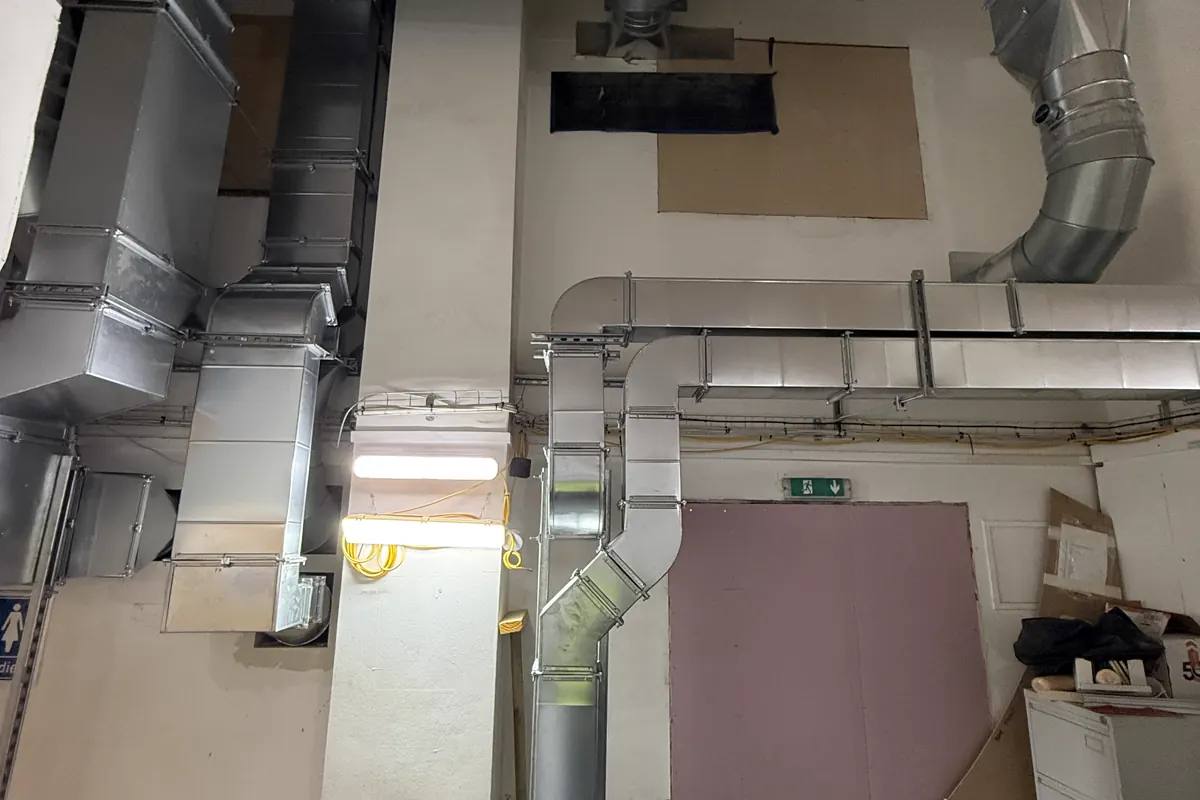 Multiple rectangular and circular ventilation duct routes installed within a commercial interior